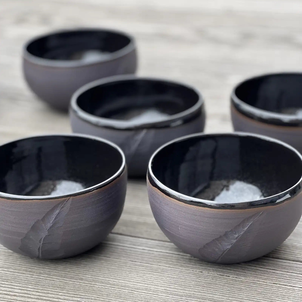 ensemble de bols noirs gravés d'une plume