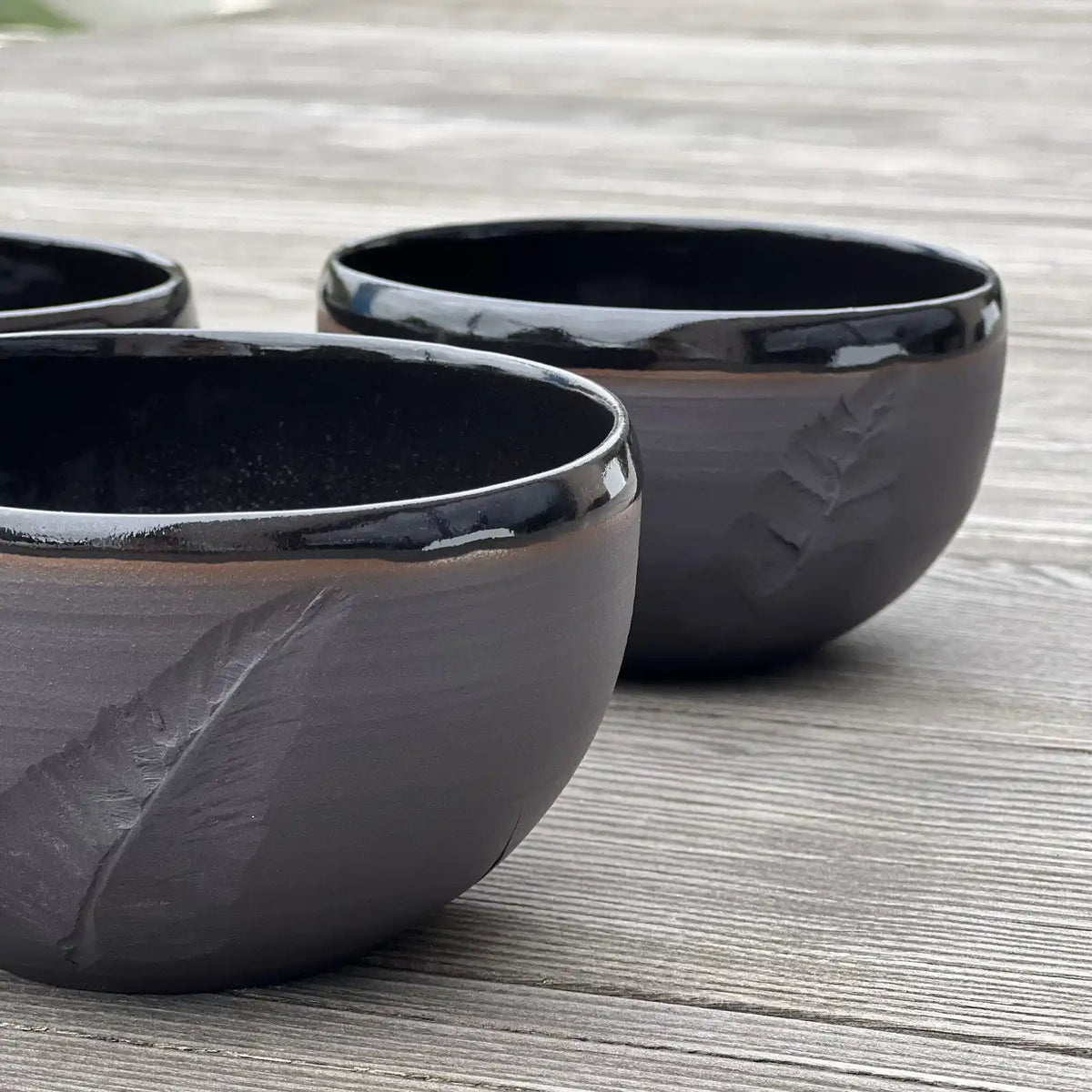 ensemble de bols noirs gravés d'une plume