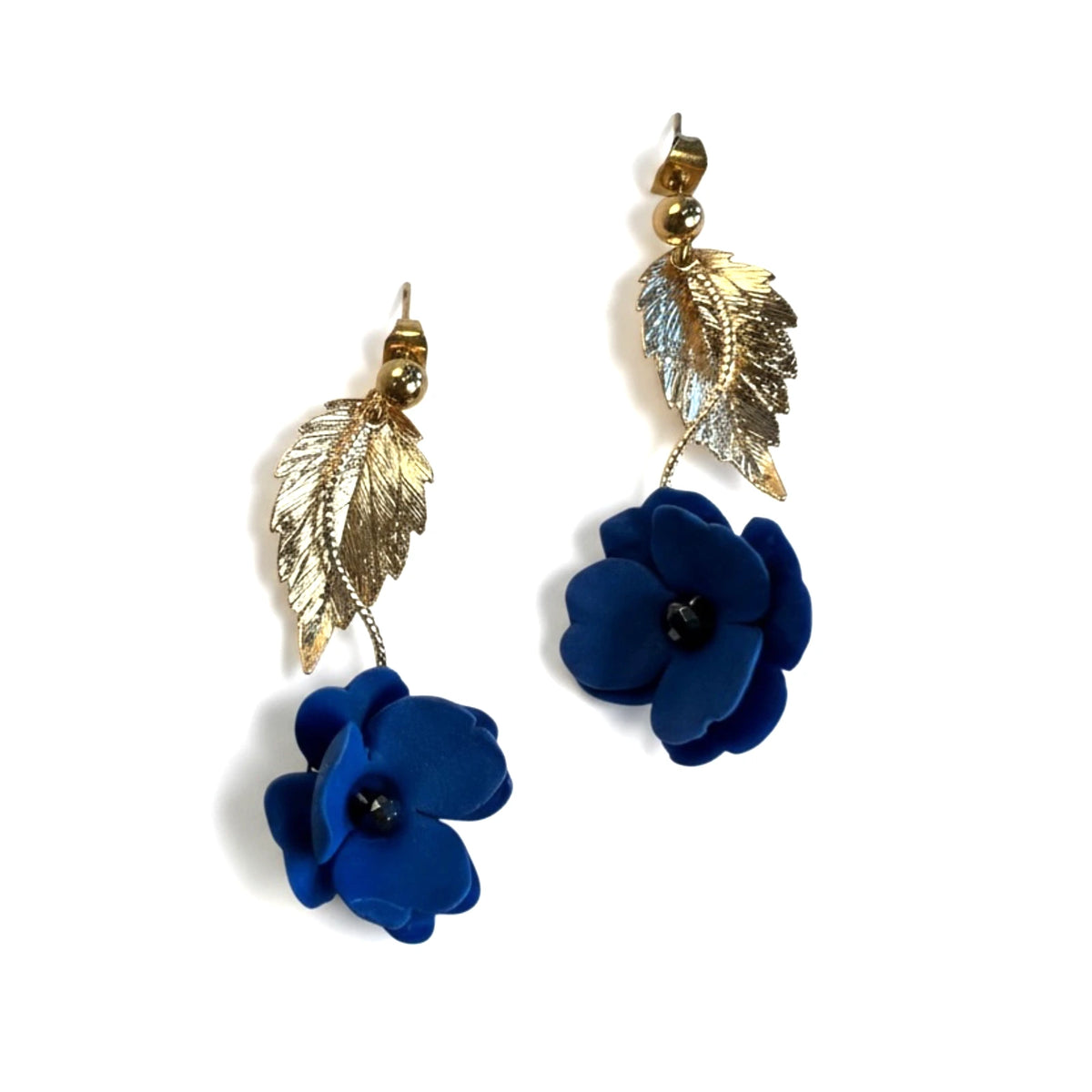 femme portant des boucles d'oreilles bleues en forme de fleur