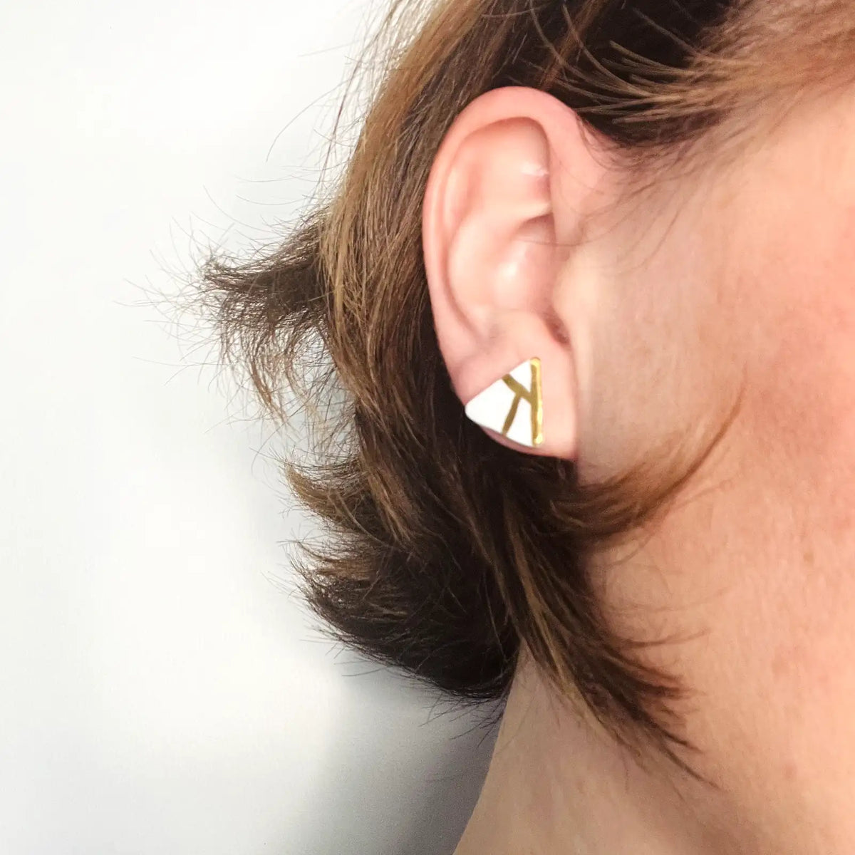 puces d'oreilles blanches décorées d'or