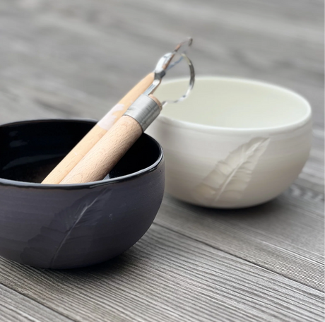 Deux bols de la collection Poëterie gravés d'une plume, contenant deux outils d'atelier