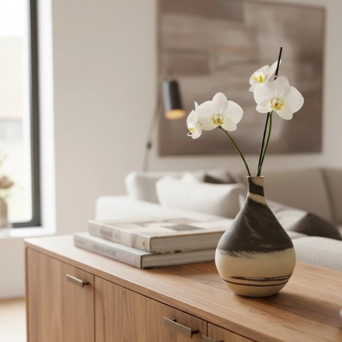 Grand vase gris et crème de la collection Diversité posé sur un bahut, garni d'une orchidée
