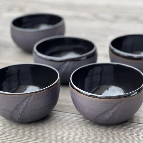 ensemble de bols noirs gravés d'une plume