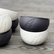 ensemble de bols noir et blanc gravés d'une plume.