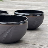 ensemble de bols noirs gravés d'une plume