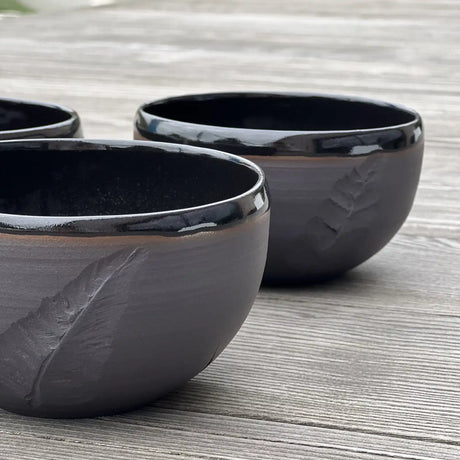 ensemble de bols noirs gravés d'une plume