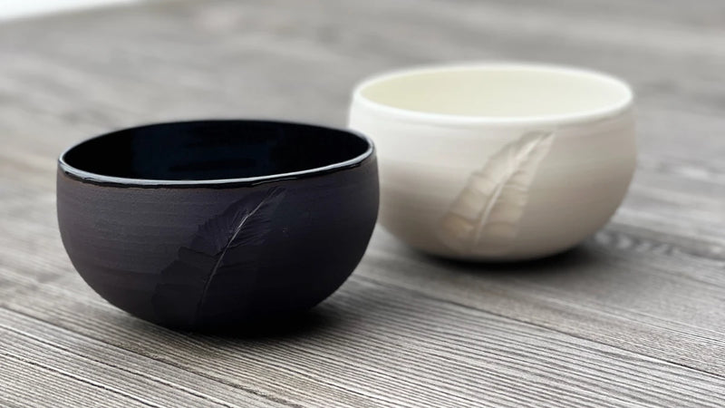Bols noir et blanc en porcelaine ornés d'une plume