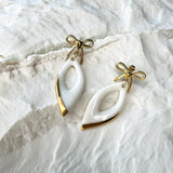 boucles d'oreilles pendantes blanches et dorées avec noeuds