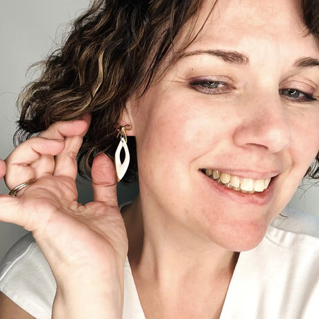 boucles d'oreilles pendantes blanches et dorées avec noeuds