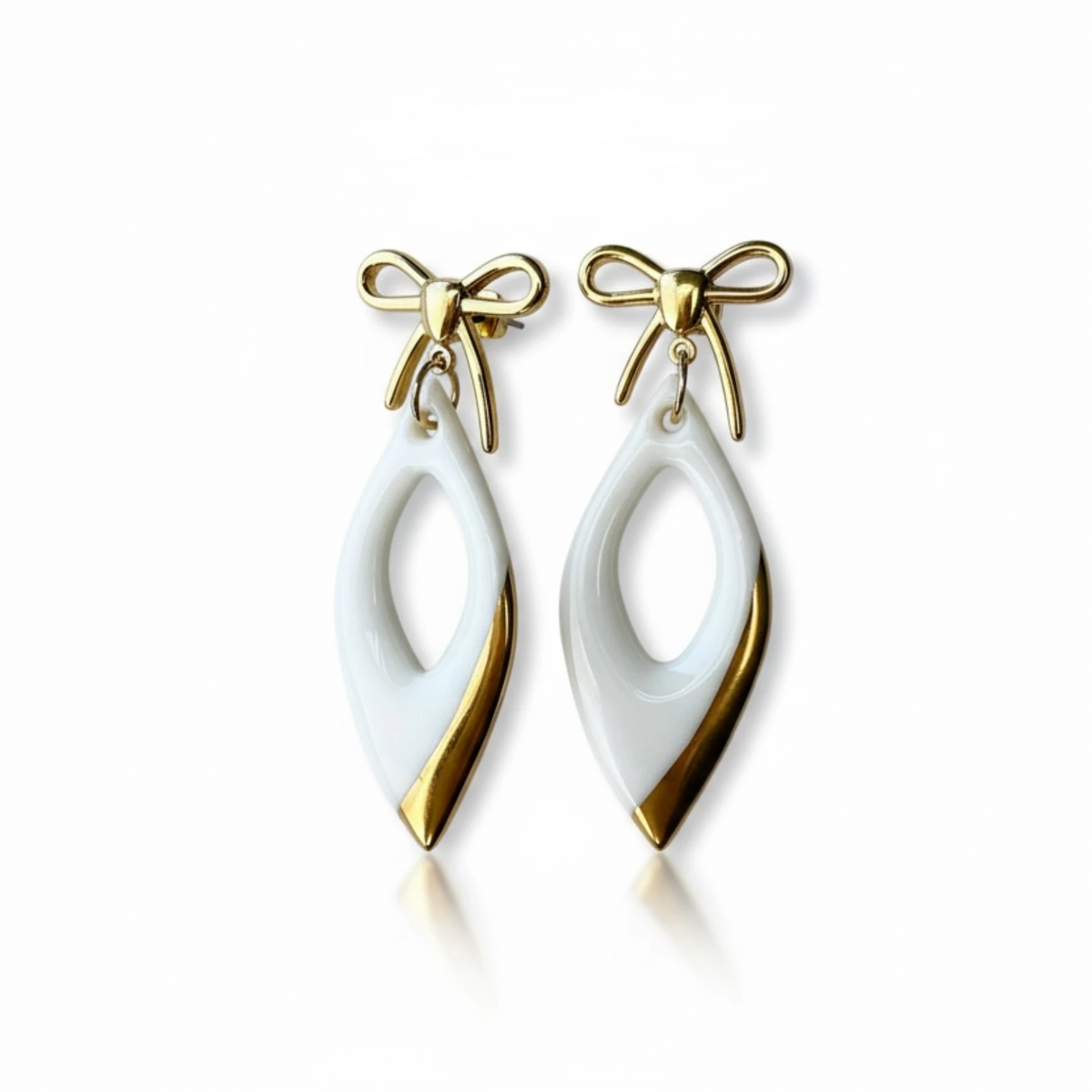 boucles d'oreilles pendantes blanches et dorées avec noeuds