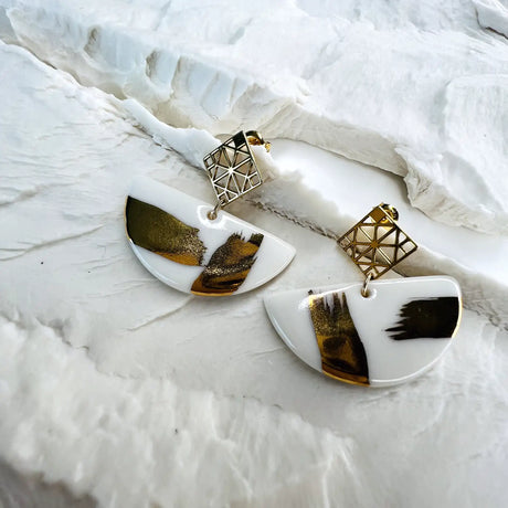 boucles d'oreilles blanches et dorées au design graphique 