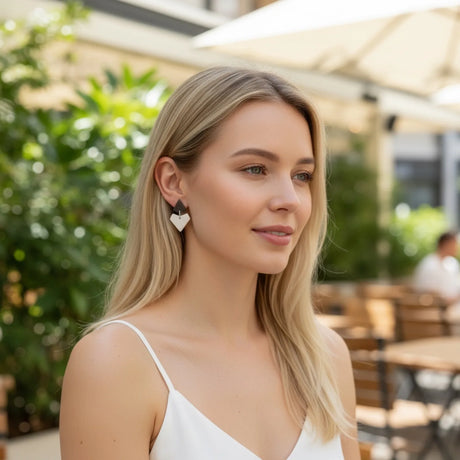 femme potant des boucles d'oreilles au design graphique noir et blanc