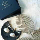 boucles d'oreilles blanches et dorées au design floral 