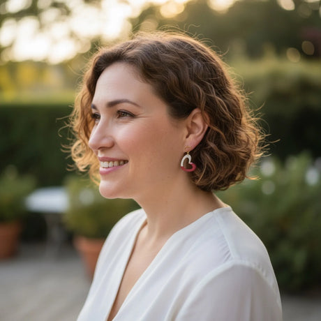 femme portant des boucles d'oreilles à coeur blanc et rouge