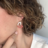 femme portant des boucles d'oreilles à coeur blanc et rouge