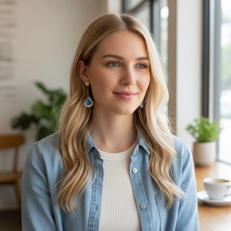 demoiselle portant des boucles d'oreilles pendantes avec pétales zébrés bleu et blanc