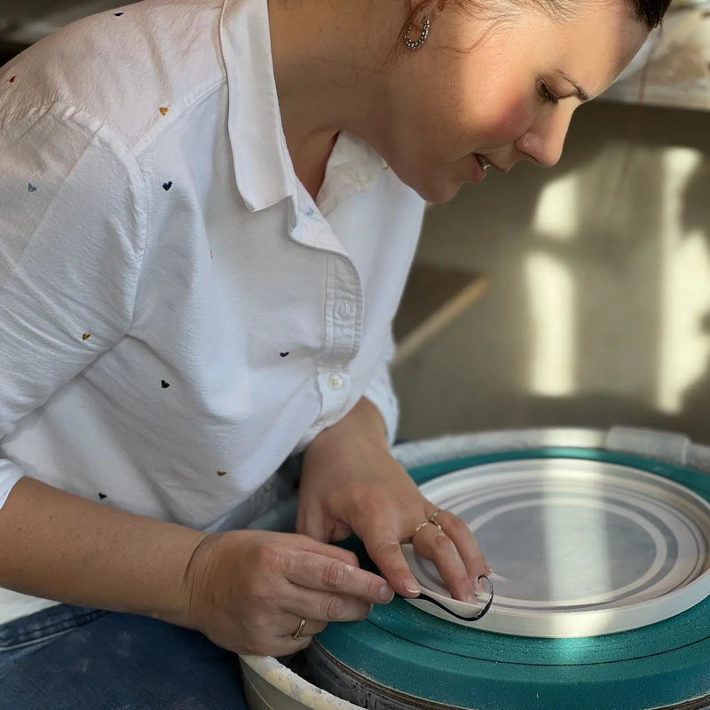 Céramiste tournassent une assiette en porcelaine