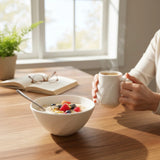 petit déjeuner dans un mug et un bol blancs gravés d'une plume