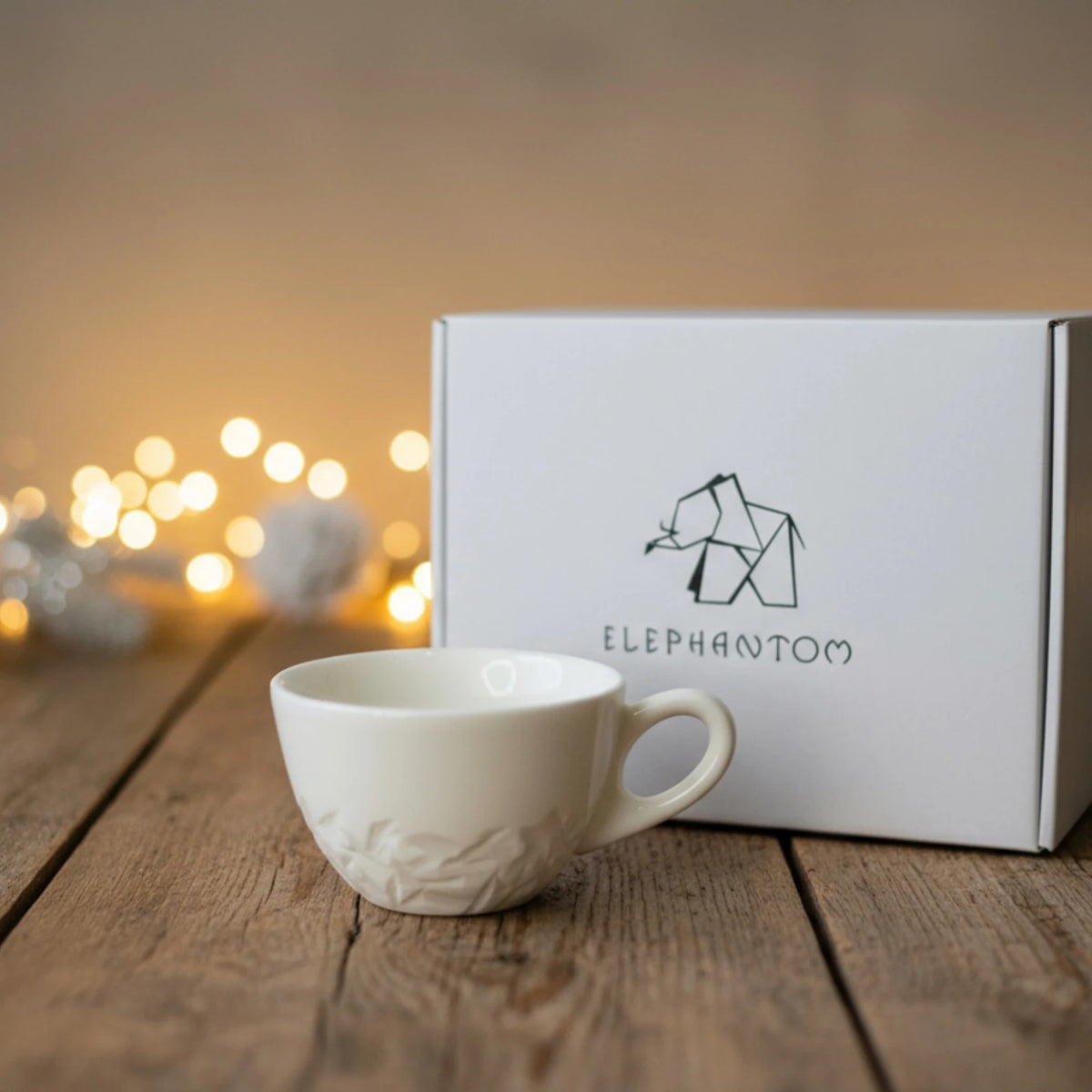 tasse blanche en porcelaine de la collection Pyrénées devant une boîte cadeau Elephantom