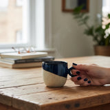 main tenant la anse d'une tasse bleue faite main Elephantom