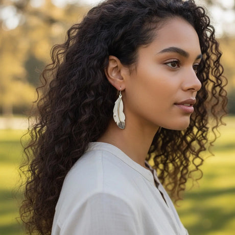 femme potant des boucles d'oreilles en forme de plumes
