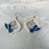 boucles d'oreilles blanches et bleues au design floral 