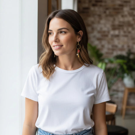 femme portant des boucles d'oreilles pendantes roses