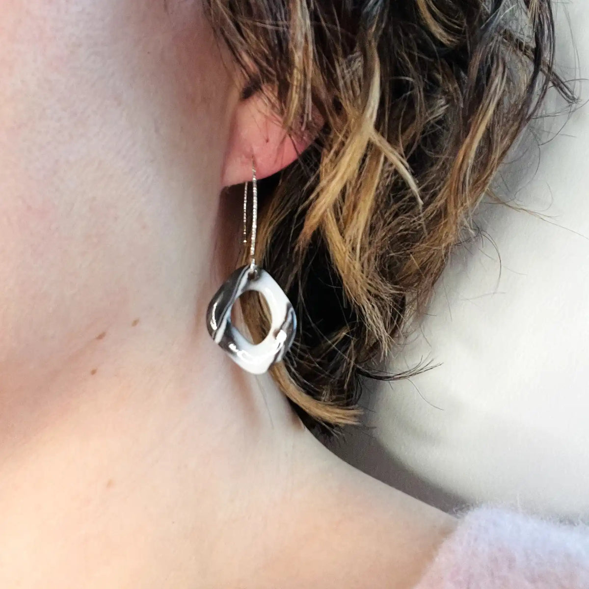 femme potant des boucles d'oreilles noires et blanches