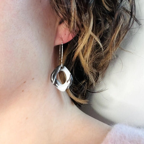 femme potant des boucles d'oreilles noires et blanches