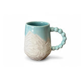 mug bleu turquoise avec motifs montagneux gravés
