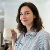 dame tenant un mug blanc gravé d'une plume