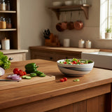 saladier noir et blanc en porcelaine contenant de la salade. Il est déposé sur un plan de travail dans une cuisine.