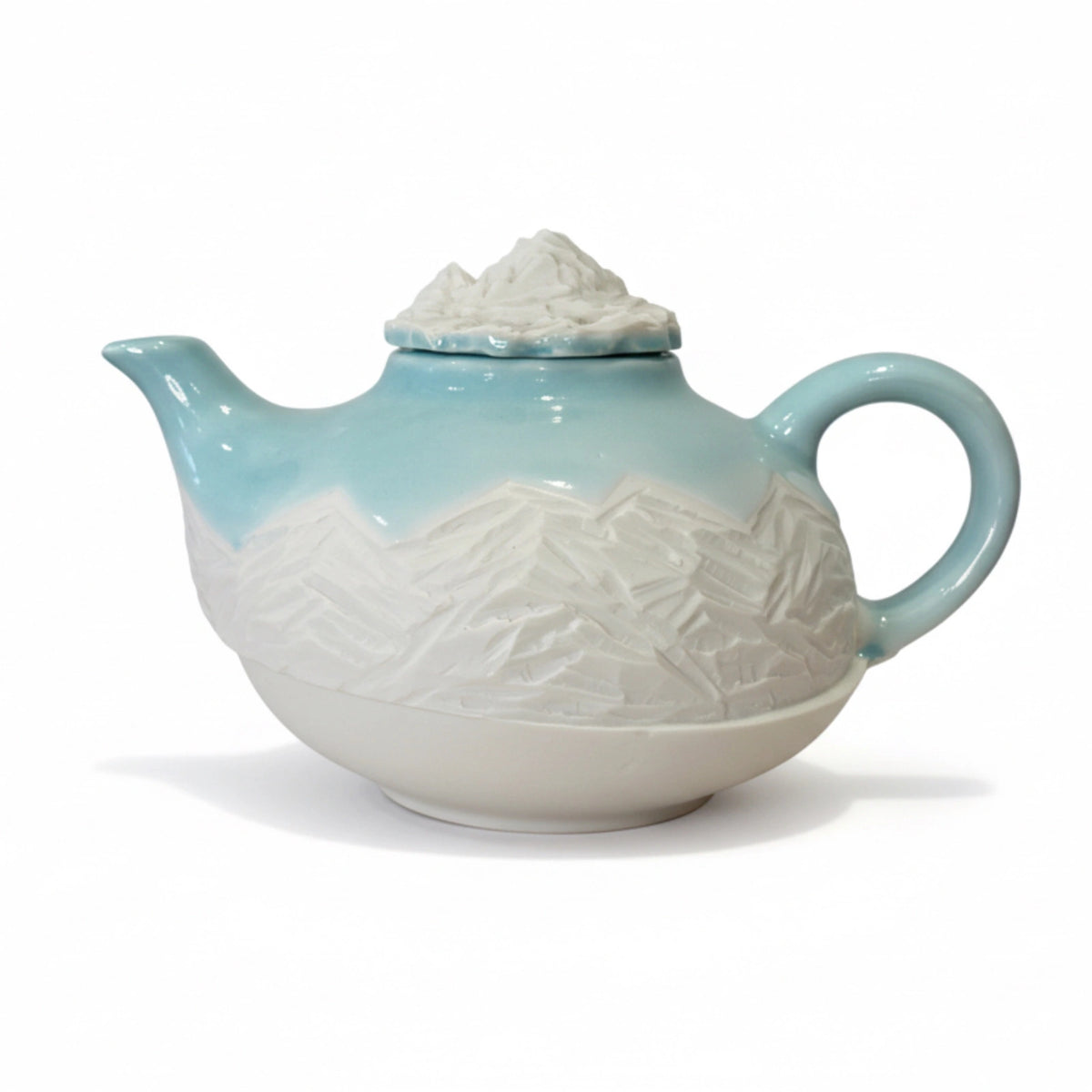 théière bleue turquoise avec motifs montagneux gravés
