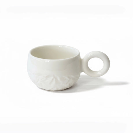  tasse blanche en porcelaine est texturée d'une montagne