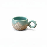 tasse bleu turquoise avec motifs montagneux gravés