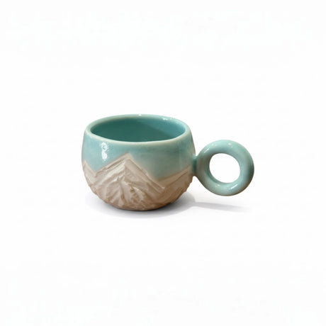 tasse bleu turquoise avec motifs montagneux gravés