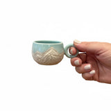 tasse bleu turquoise avec motifs montagneux gravés