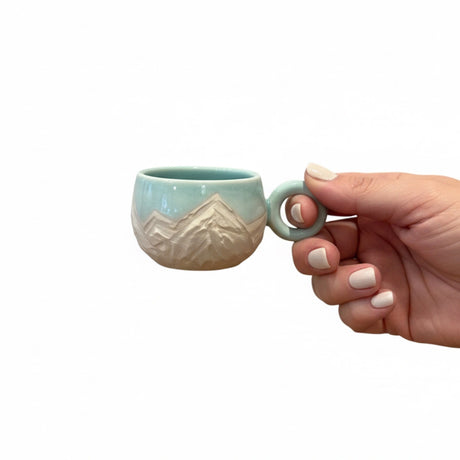 tasse bleu turquoise avec motifs montagneux gravés