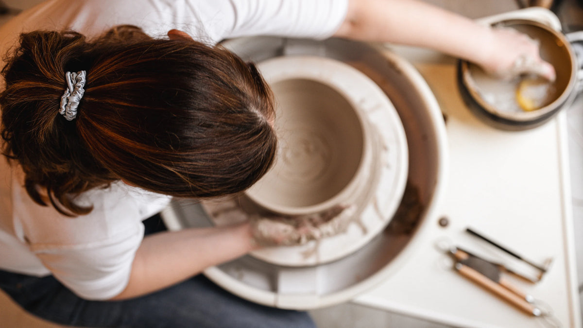Mains façonnant l'argile sur le tour de potier, atelier Elephantom